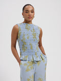 Blue smocked sleeveless top with yellow floral print and ruffle hem by Nous Sommes Labels 