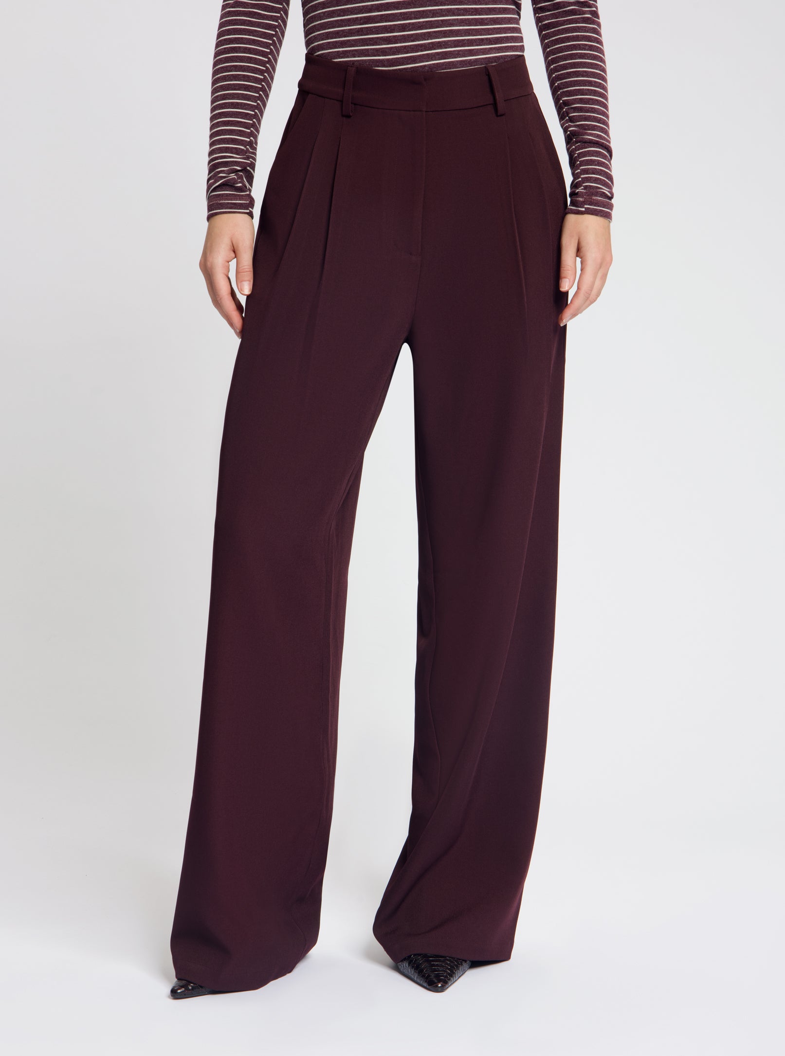 Model wearing the Josie Pleated Trousers in Burgundy - NOUS SOMMES LABELS