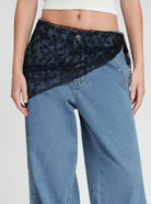 Black lace scarf styled as a wrap over low-rise wide-leg jeans - floral embroidered sheer lace with scalloped trim